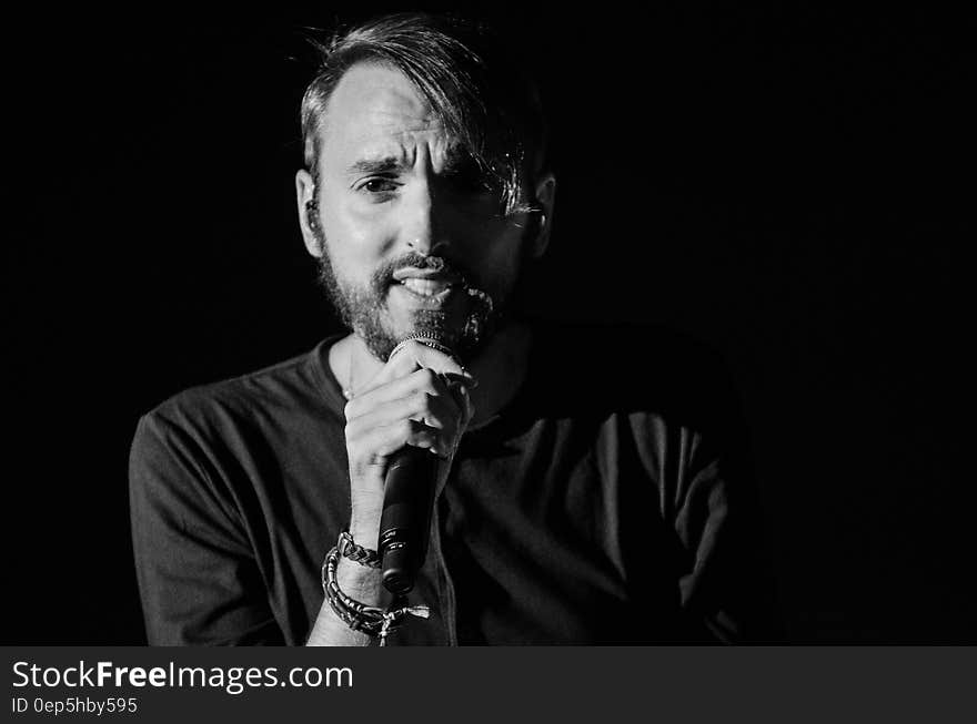 Grayscale Photo of Man Holding Microphone