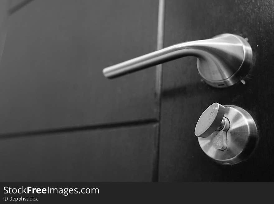 Close up of metal door knob and dead bolt lock on door in black and white. Close up of metal door knob and dead bolt lock on door in black and white.