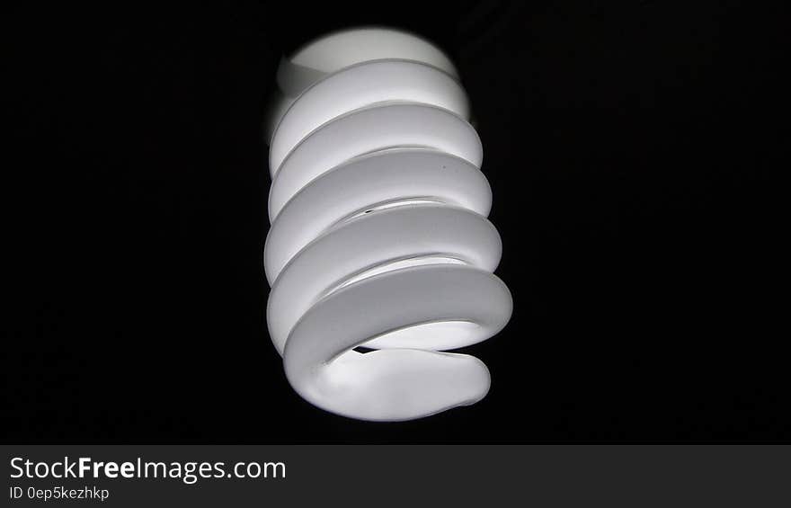 Close up of energy efficient electric light bulb on black background.