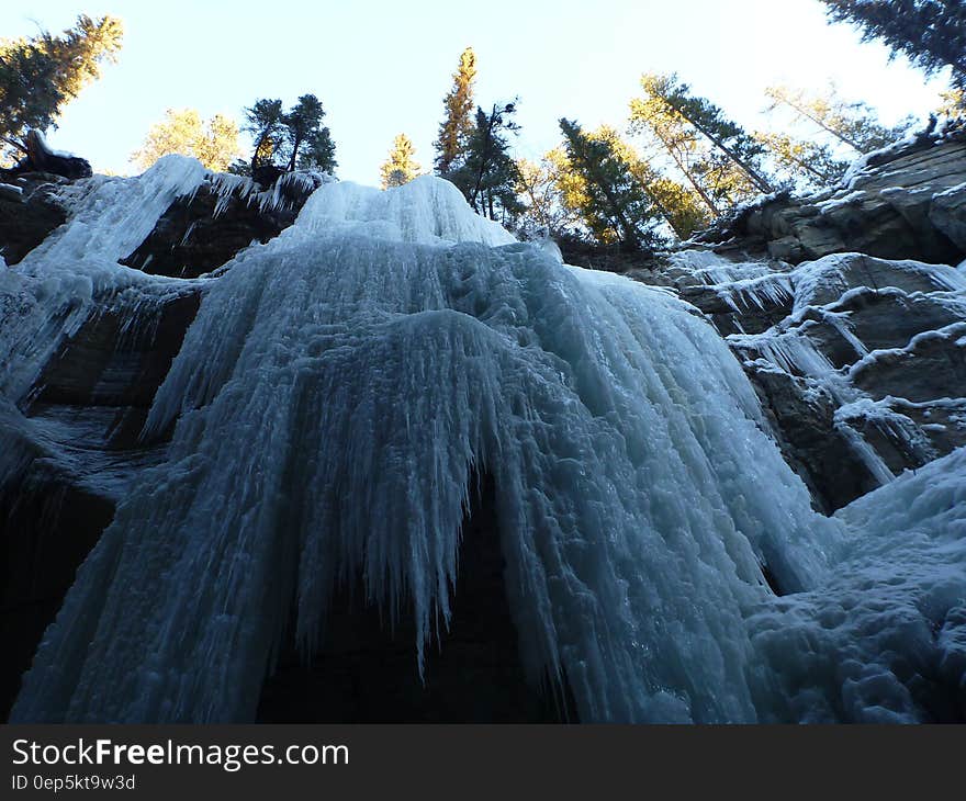 Frozen icicles on waterfalls over steep rocks on sunny day. Frozen icicles on waterfalls over steep rocks on sunny day.