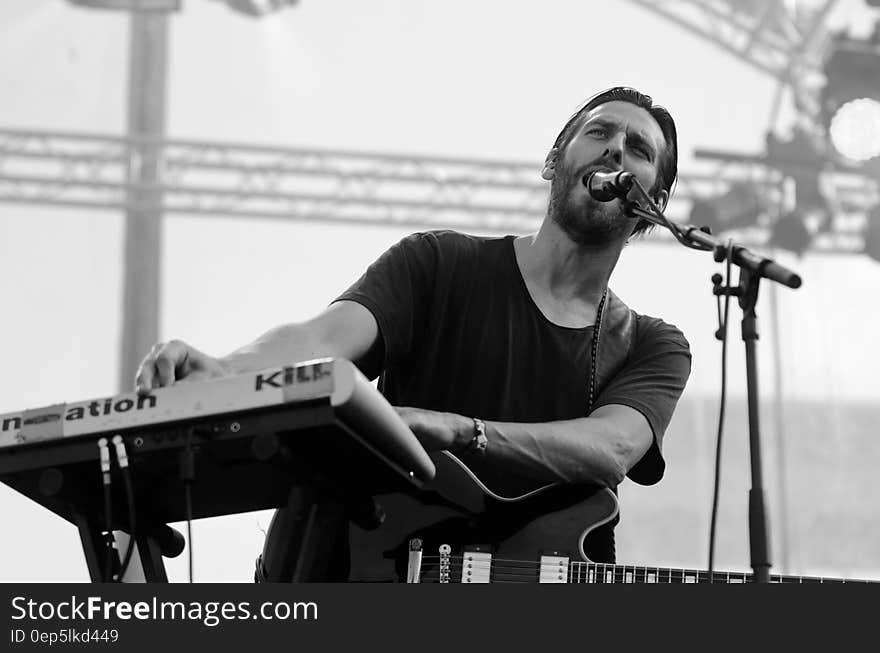 Grayscale Photo of Man Playing Electric Keyboard