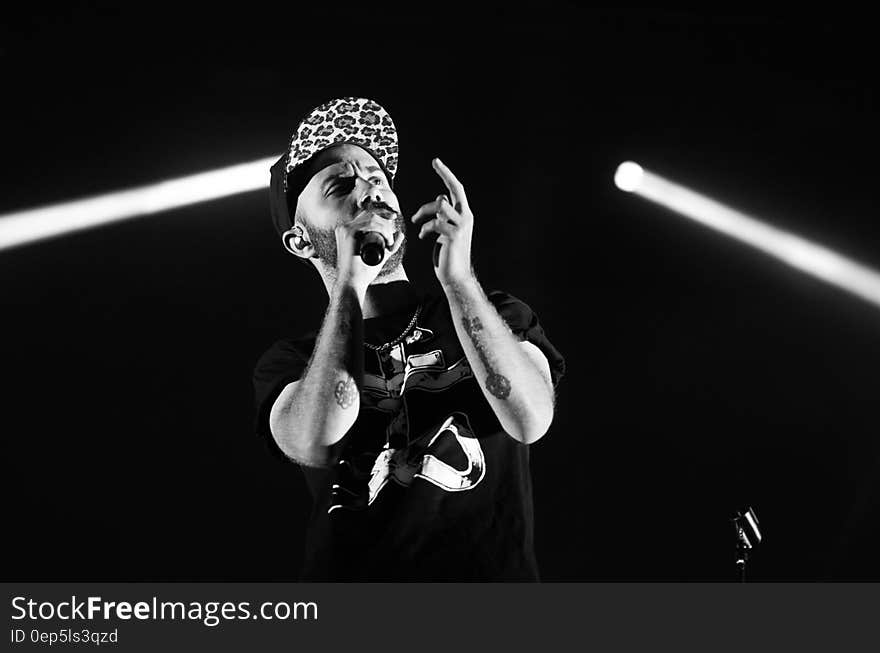 Man in Crew Neck Shirt Holding a Microphone