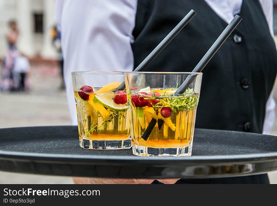 2 Whisky Glasses Filled With Beverage on Black Tray