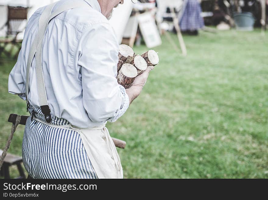 Man in White Dress Shirt Carrying Brown Wood Logs