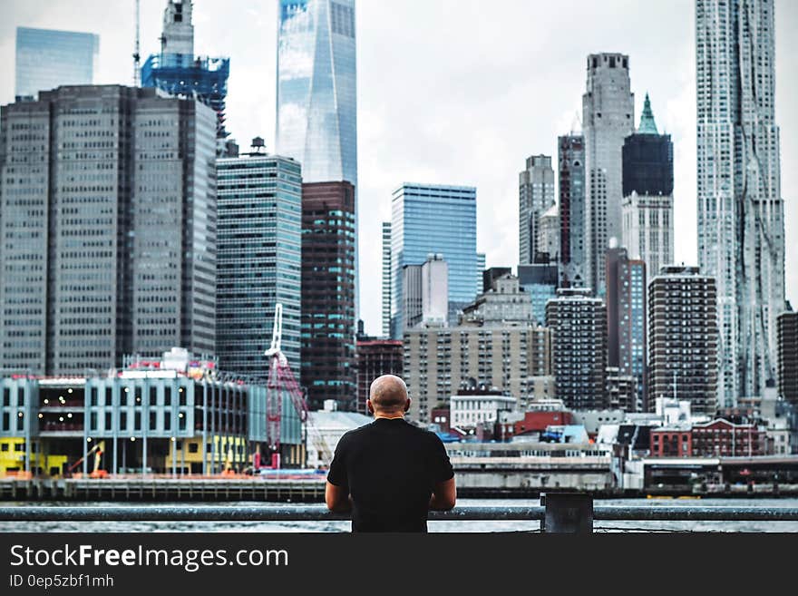 Man in Black T Shirt in Front on City Skyline during Daytime