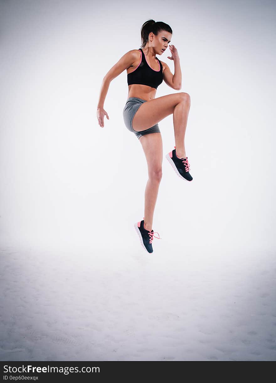 A sporty woman jumping in fitness outfit.