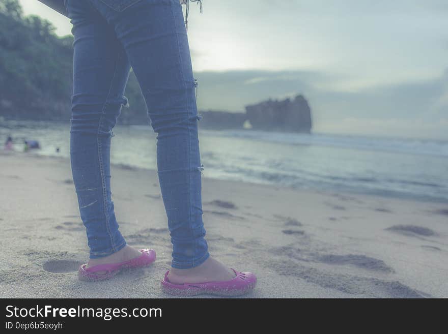 Person in Blue Jeans and Pink Flats in Front of Seashore