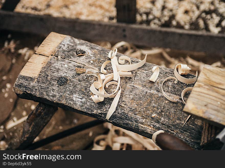 Close up of wood shavings on wooden plank in carpentry shop. Close up of wood shavings on wooden plank in carpentry shop.