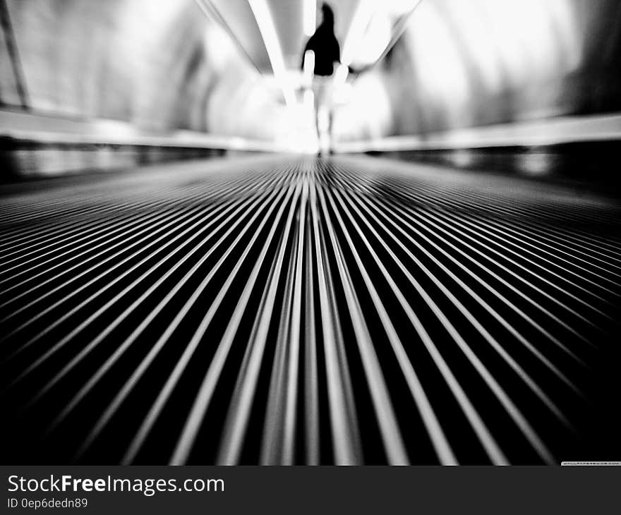 Greyscale Photography of Man Walking on Tunnel