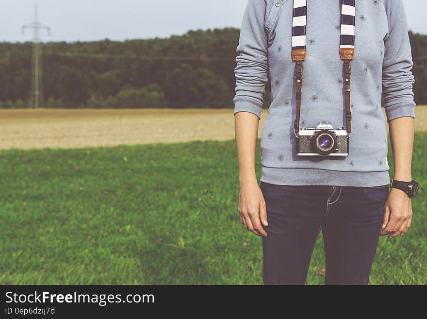 Man Standing Carrying Dslr Camera during Daytime