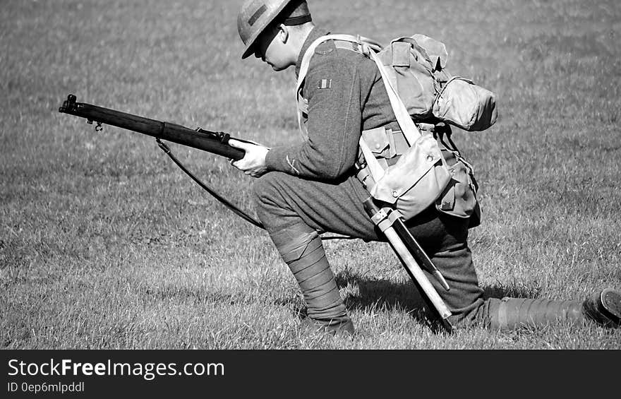 Man in Soldier Suit Holding Gun Knees Down in the Ground