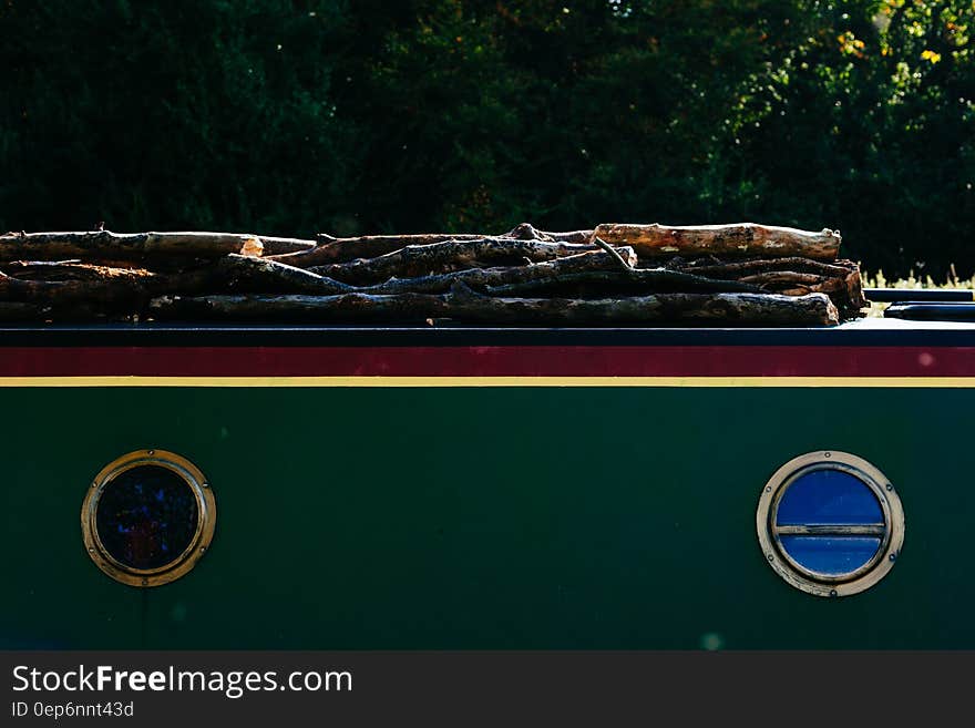 A cargo boat transporting wood on the deck.