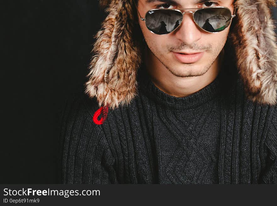 A man wearing a fur hat and sunglasses. A man wearing a fur hat and sunglasses.