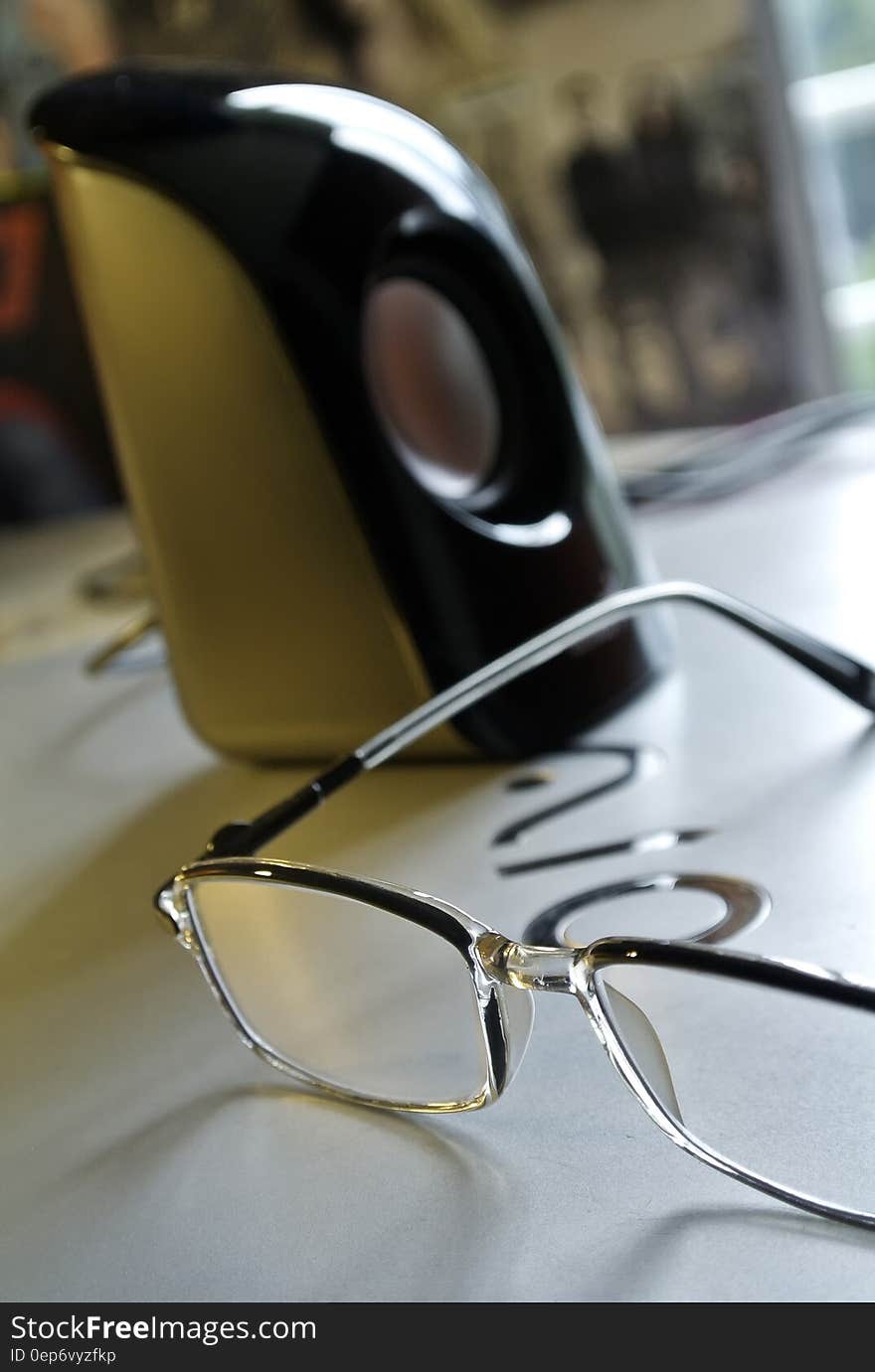 Black Frame Eyeglass Beside Black and White Electric Kettle