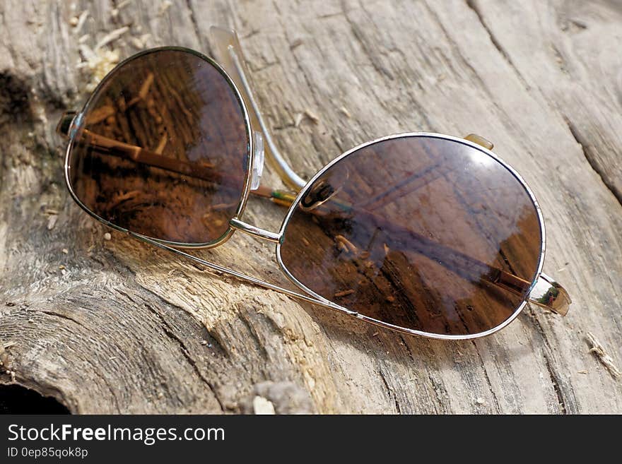 Silver Aviator Sunglasses on Top of Wooden Surface