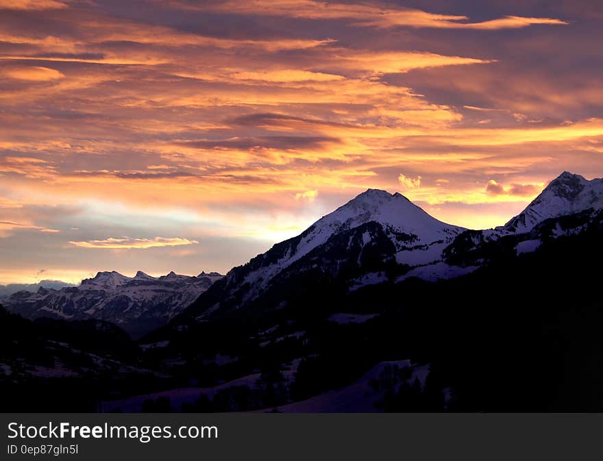 Snow Mountain Under Orange Skies