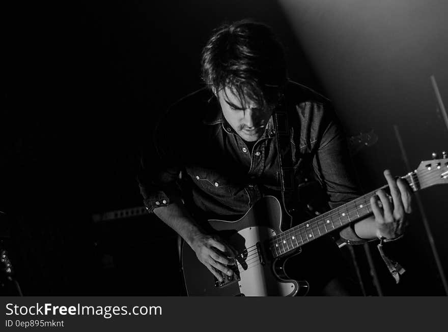 Grayscale Photo of Man Playing Electric Guitar