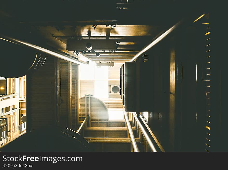 View up or down a lift shaft showing converging rails in low light conditions. View up or down a lift shaft showing converging rails in low light conditions.