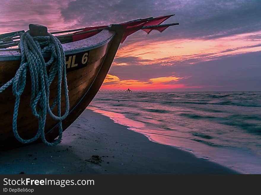 Brown Wooden Boat on Shore during Sunset