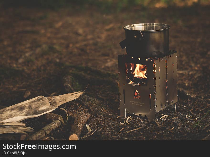 Stainless Steel Pot on Brown Wood Stove Outside during Night Time