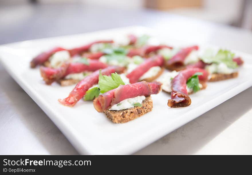 Close up of white plate with rolled ham finger sandwiches. Close up of white plate with rolled ham finger sandwiches.