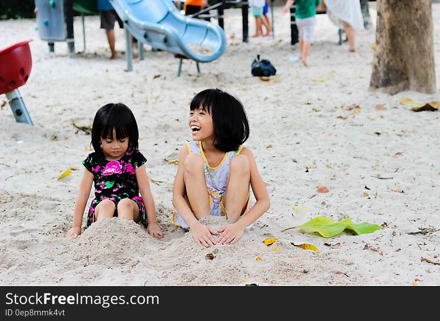 2 Girls Sitting on Seashore