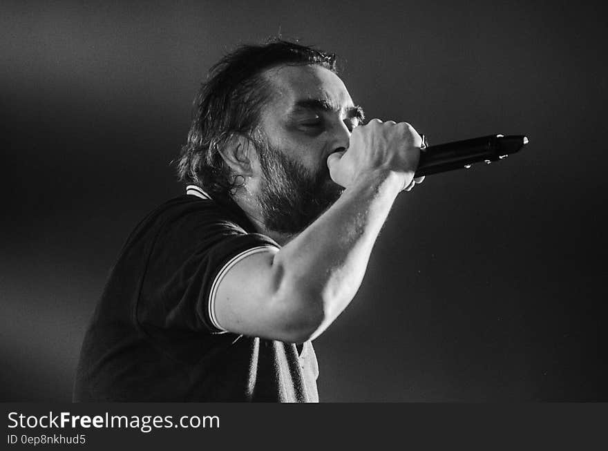 Man Singing Wearing Black Polo Shirt