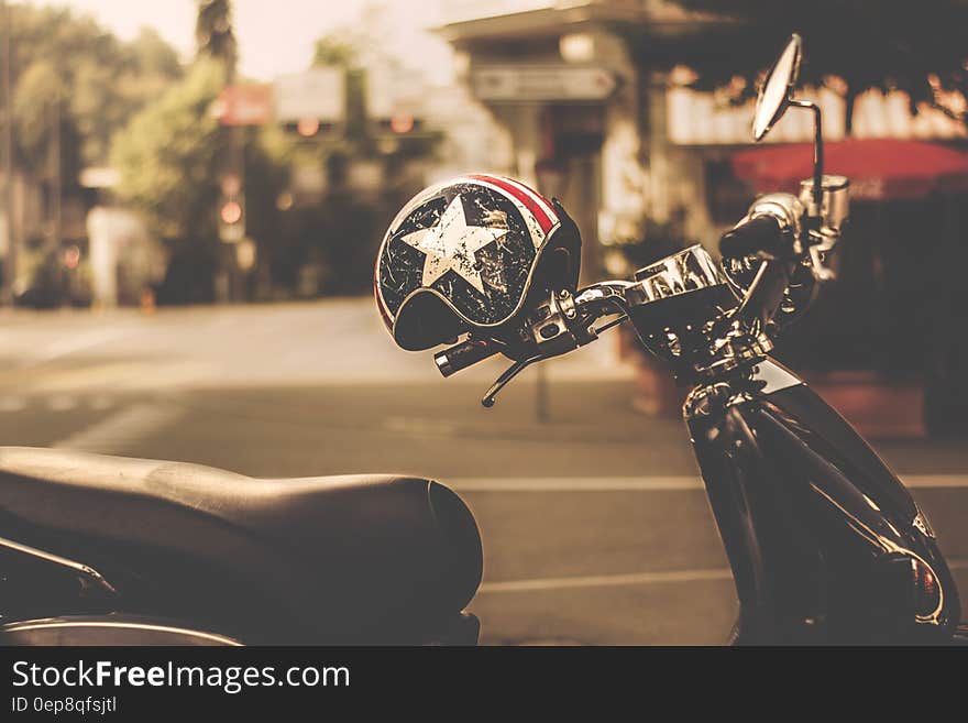 Black and Gray Motor Scooter With Black and White Star Print Half Face Helmet