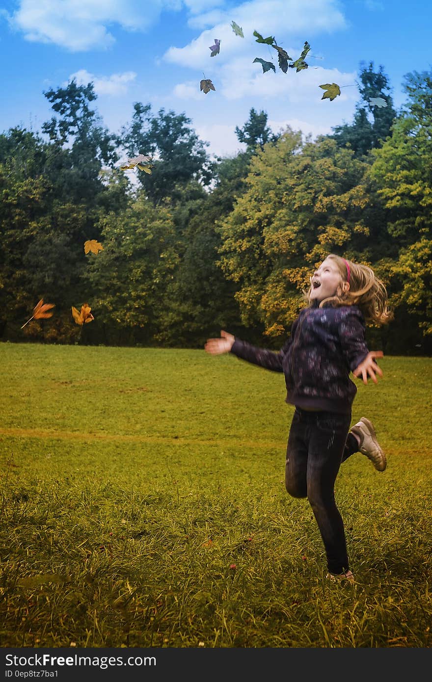 Girl in Black Jacket Standing on Green Grass during Daytime