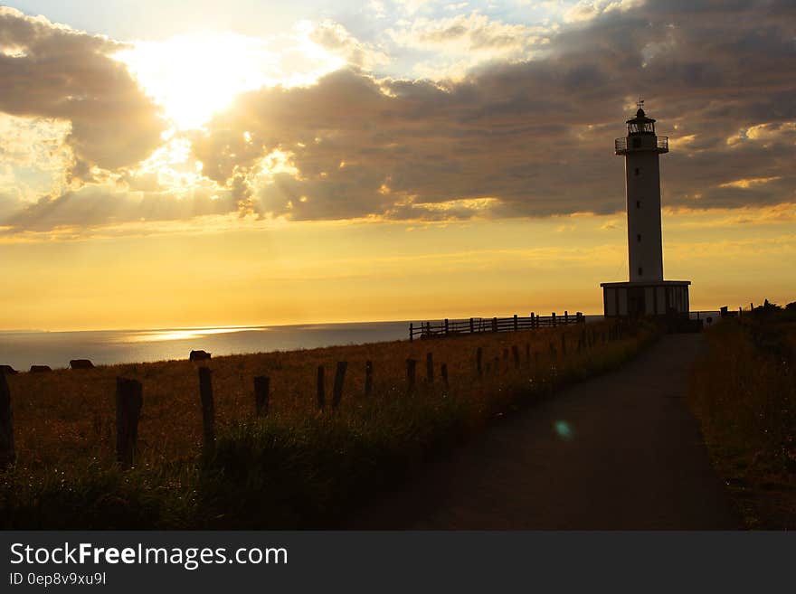 Lighthouse Near Ocean during Golden Hour