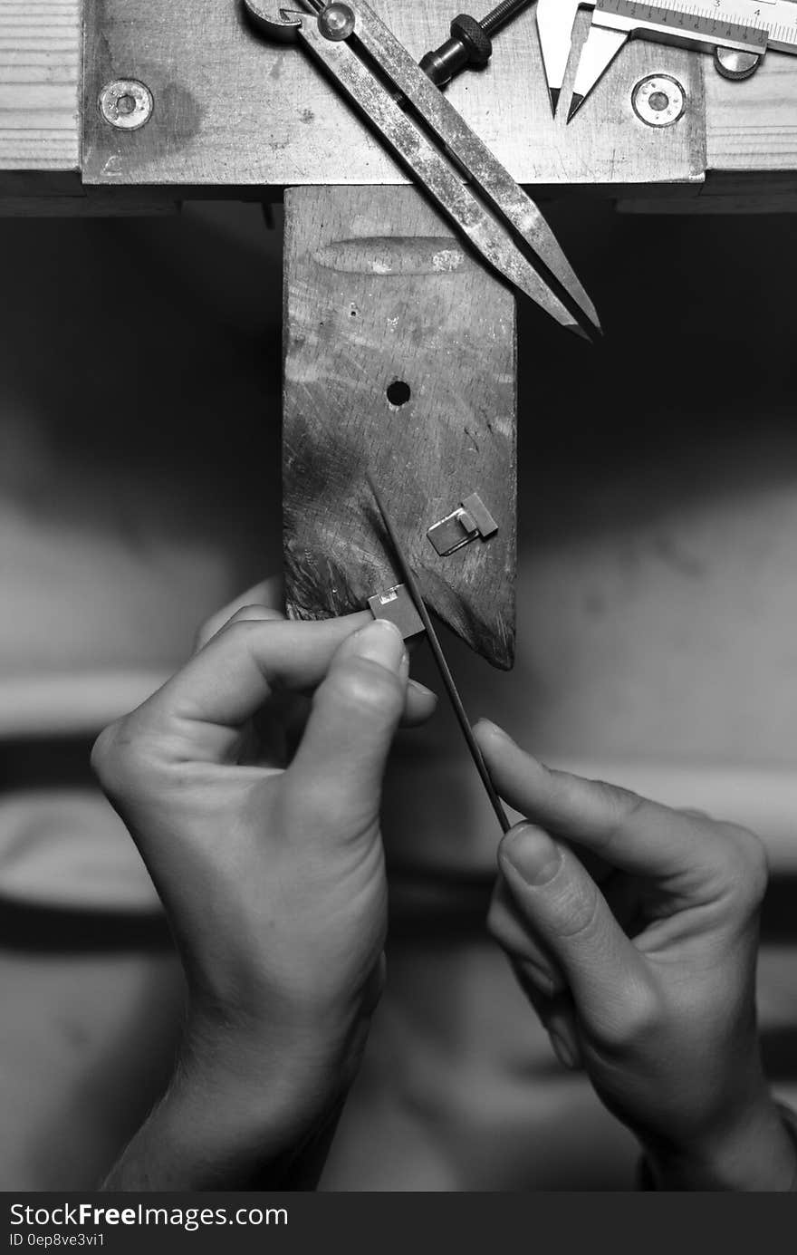 A black and white close up of precise handicraft using different tools.