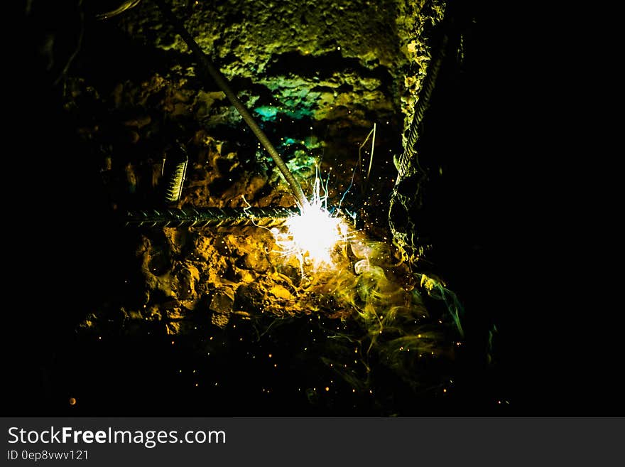 Bright sparks flying from welding rod striking electric arc on a piece of rebar. Bright sparks flying from welding rod striking electric arc on a piece of rebar.