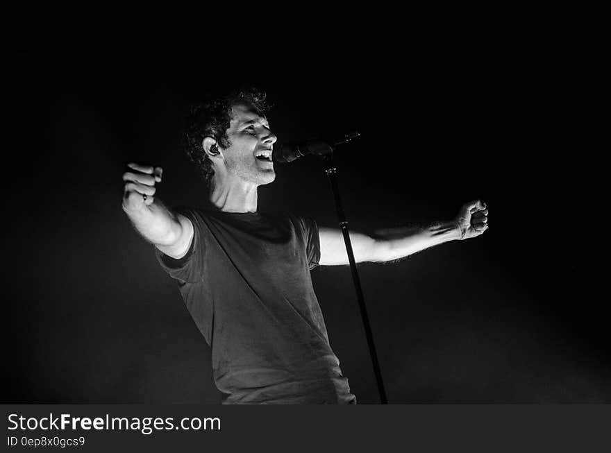 Greyscale Photo of Man Singing