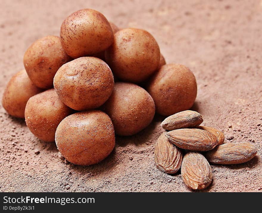 Almonds and potatoes on mound of dark cocoa powder.