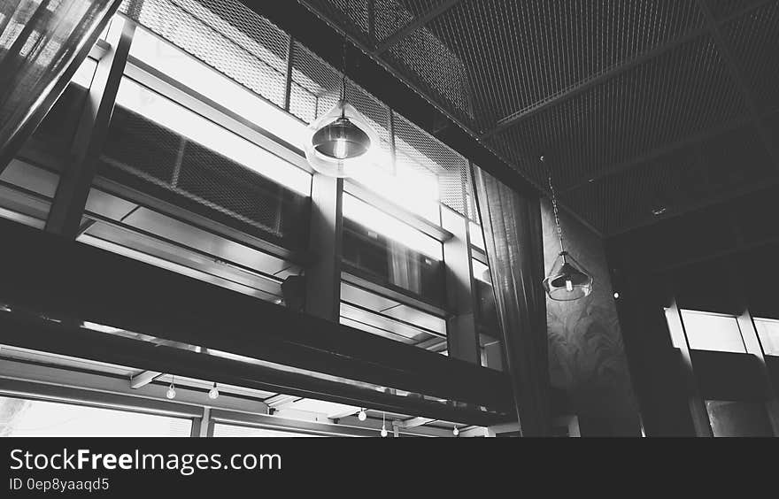 Grayscale Photo of Hanged Ceiling Lamp Inside the Building