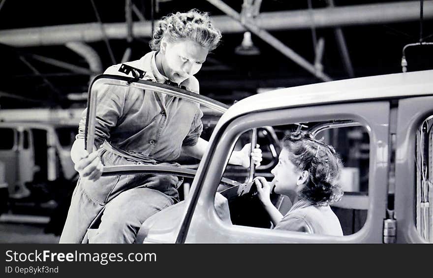 Man Carrying Car Windshield With Woman Inside a Car