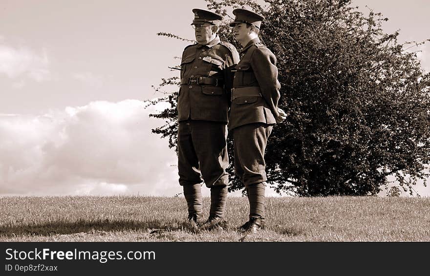 Two Soldier Standing on Grass during Daytime