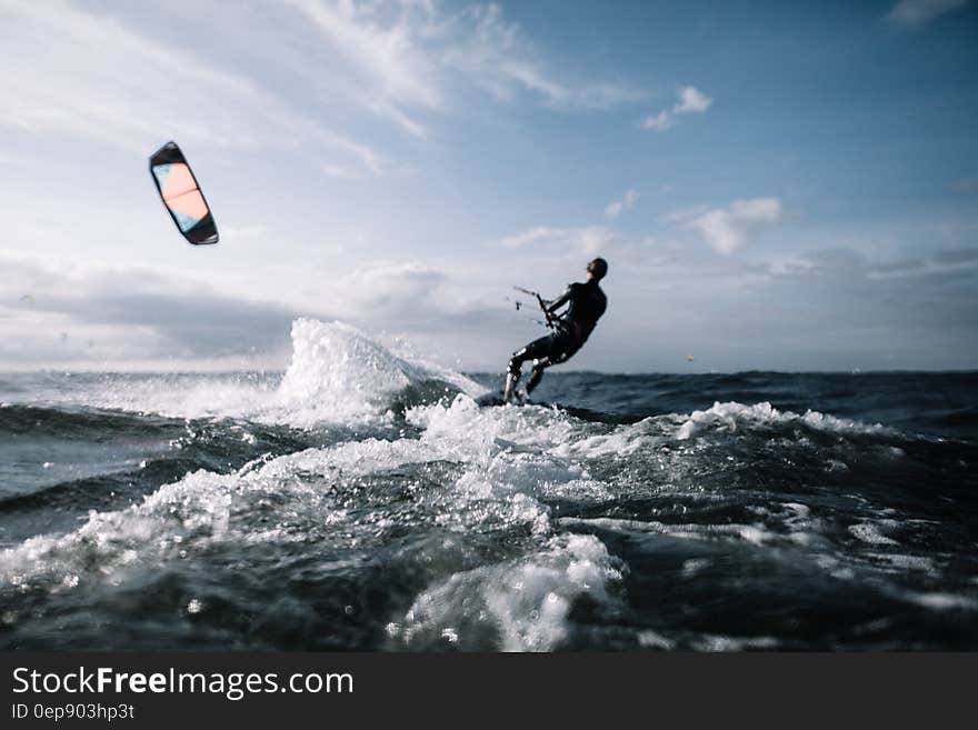 Kitesurfing in blue waters on sunny day.