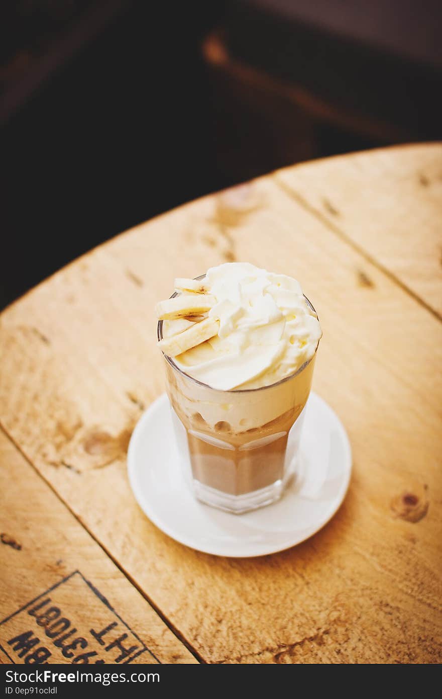 Photo of Clear Glass Cup With Whip Cream on Top Place on Saucer