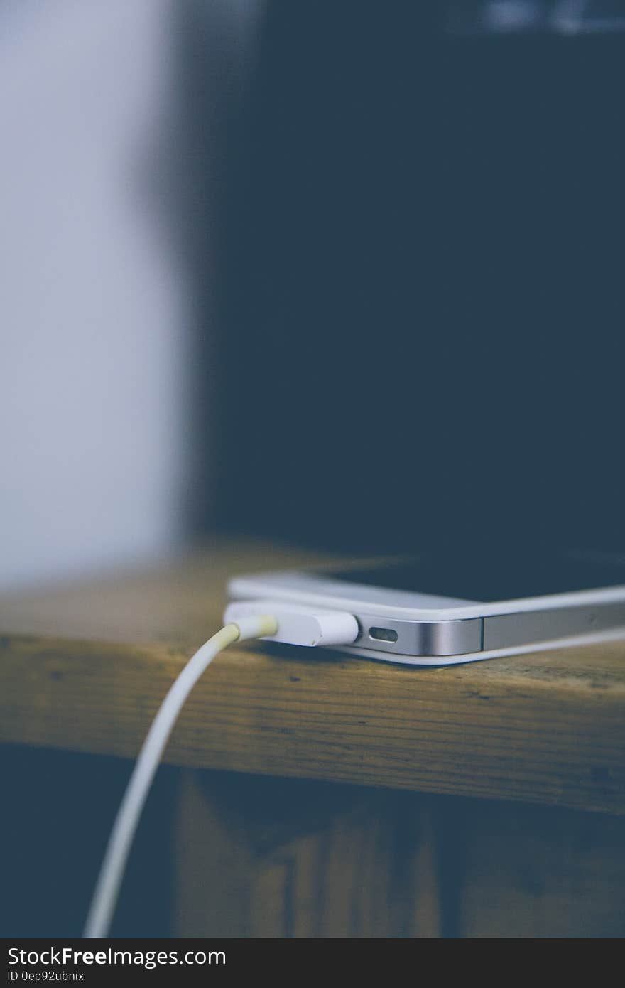 White Iphone 4 at Top of Brown Table