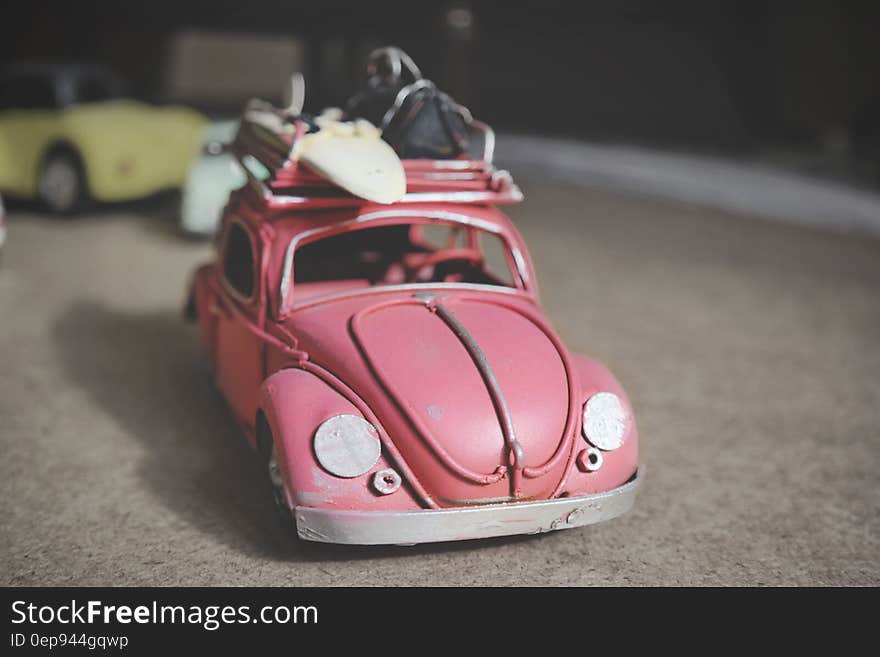 Vintage toy pink Volkswagen Beetle car with surf board. Vintage toy pink Volkswagen Beetle car with surf board