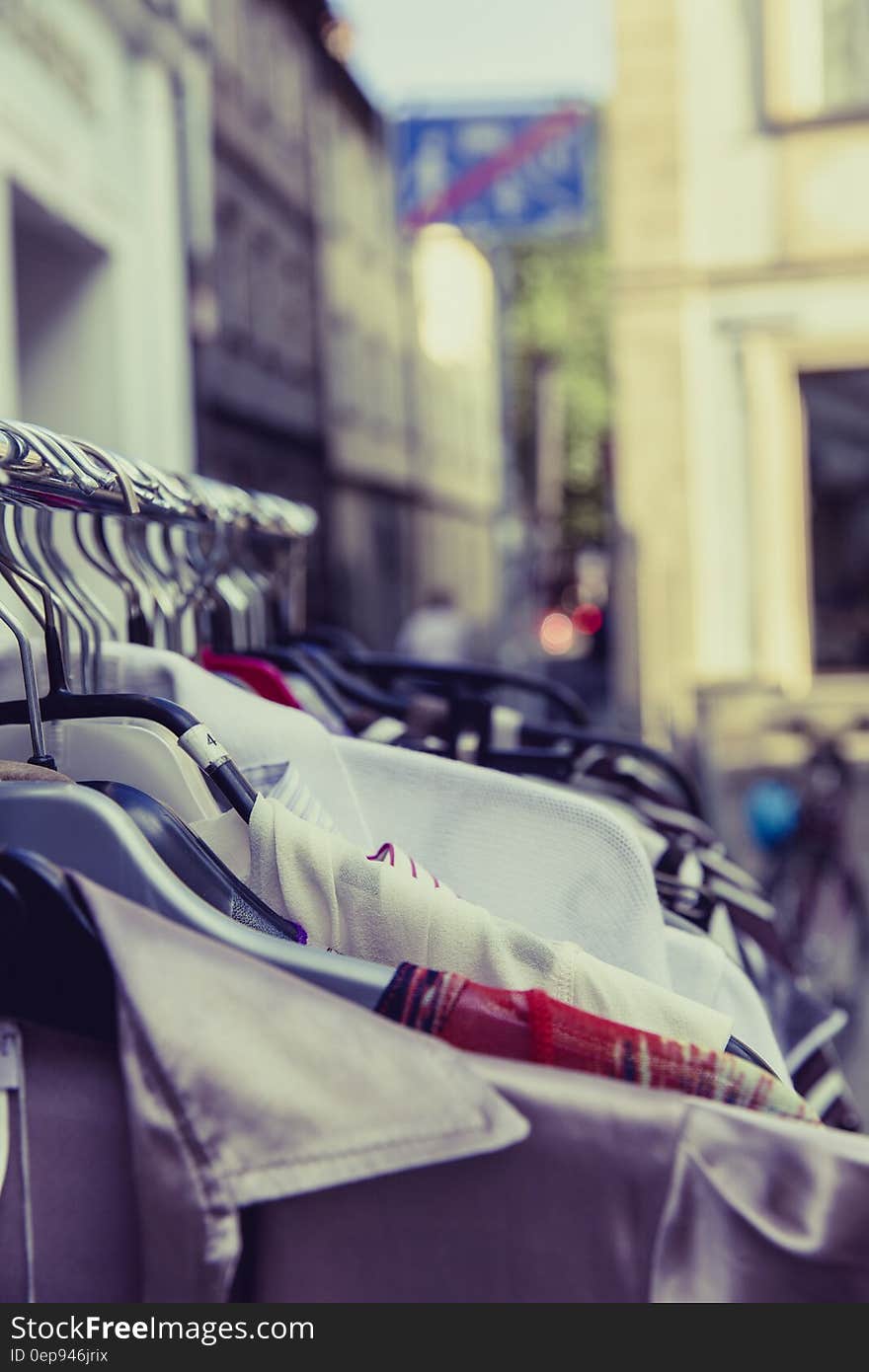 Shallow Focus Photography of Shirts Hang on Silver Clothes Rack Under Sunny Sky