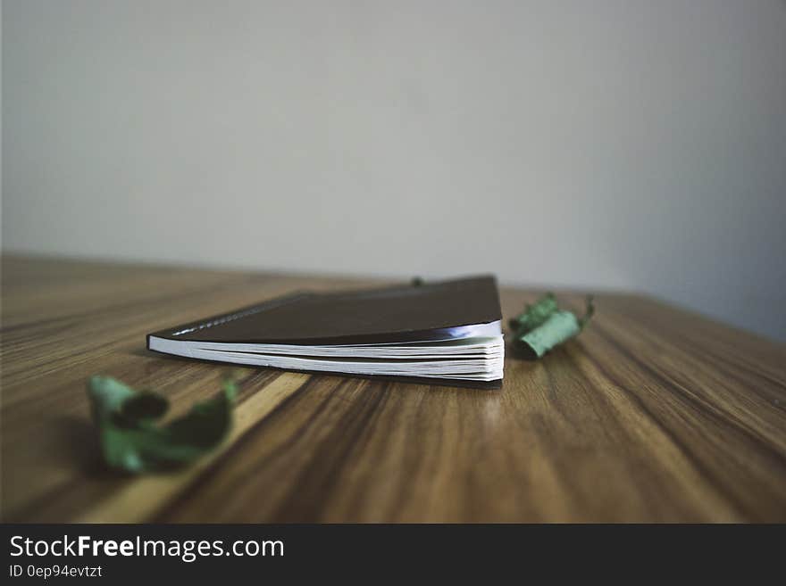 Black Small Notebook on Brown Wooden Surface