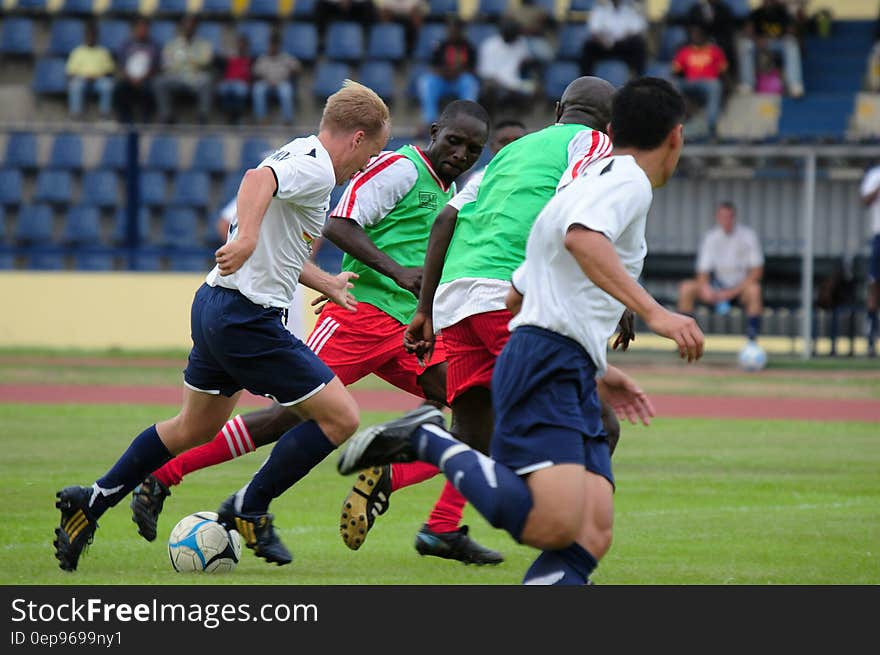 Players dribbling soccer ball down court in outdoor match. Players dribbling soccer ball down court in outdoor match.