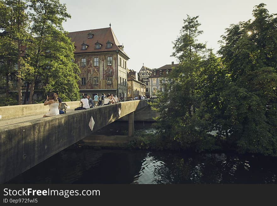 People Walking on Bridge Near the Town during Daytime