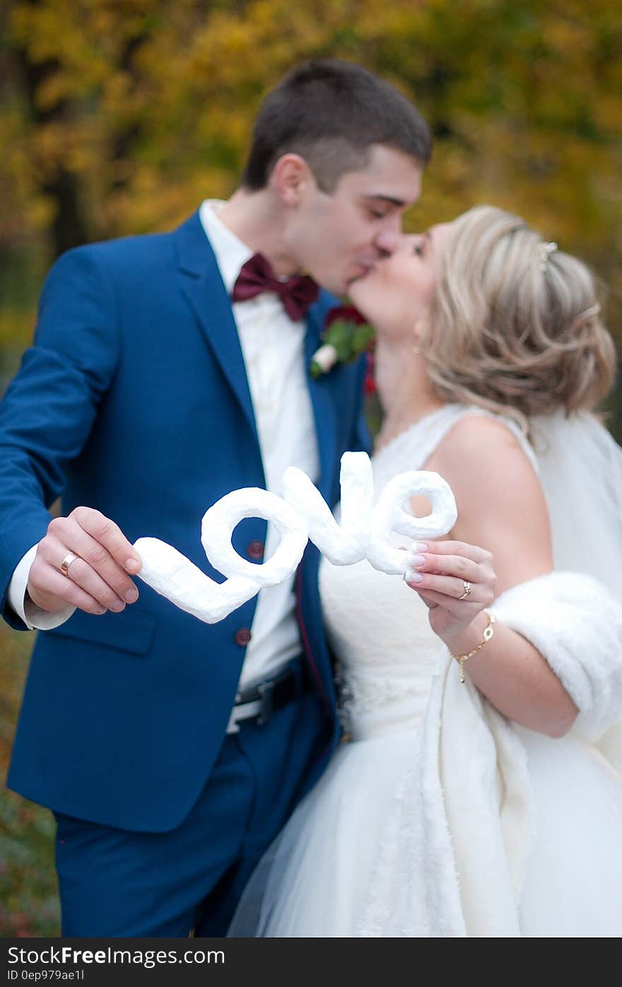 Newly Wed Couple Kissed Each Other While Holding Love Cutout