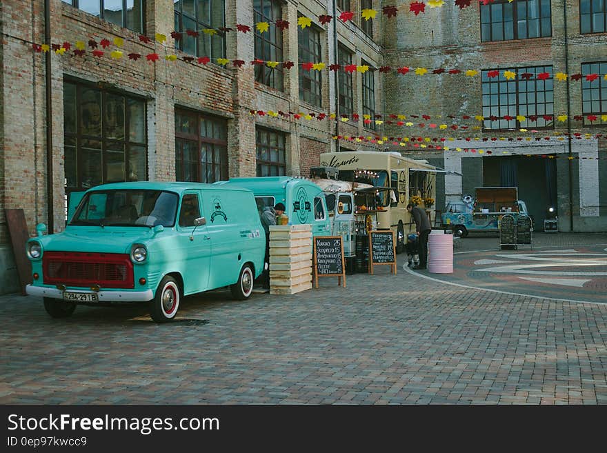 Green Minivan Near Brown Wooden Crate and Brown Food Truck