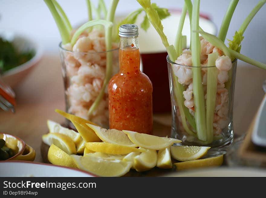 Fresh celery stalks in glasses with citrus dipping sauce and lemon wedges. Fresh celery stalks in glasses with citrus dipping sauce and lemon wedges.