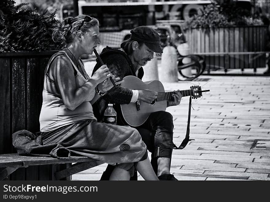 Greyscale Photography of Man and Woman Playing Musical Instruments