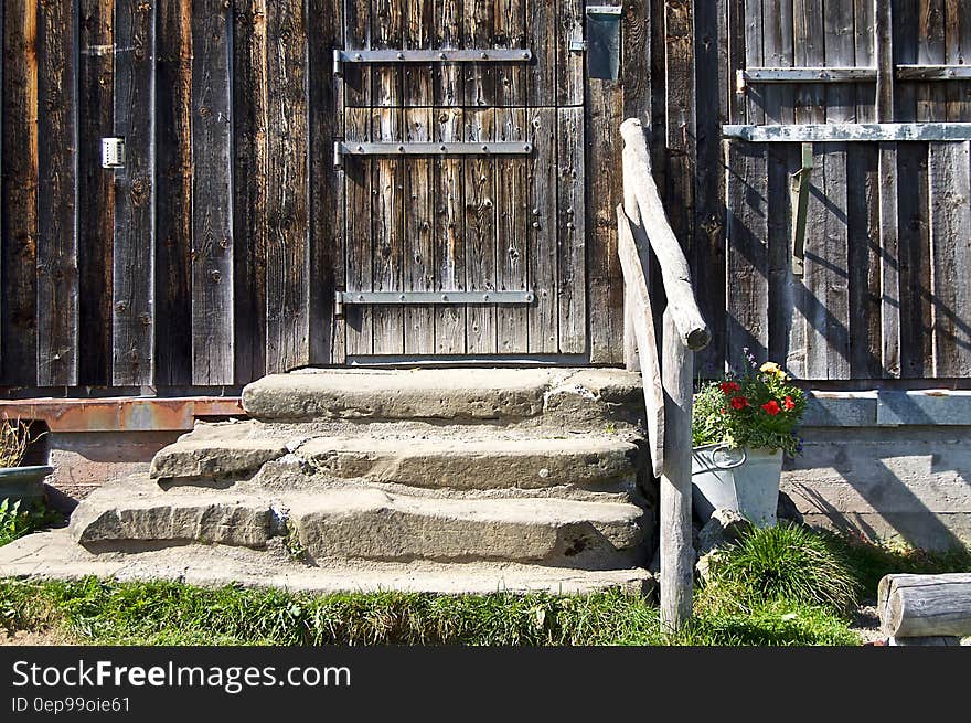 Stone steps leading to worn wooden door outside house on sunny day. Stone steps leading to worn wooden door outside house on sunny day.